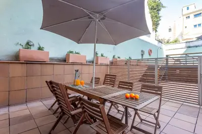 a table and chairs with an umbrella on a patio at My Space Emirates - Bright Apartment in Gracia with shared Pool in Barcelona