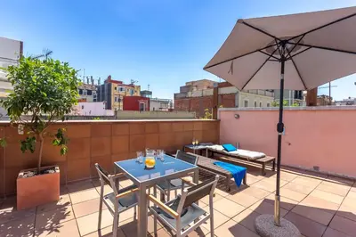a patio with a table and an umbrella on a roof at My Space Emirates - Bright Apartment in Gracia with shared Pool in Barcelona