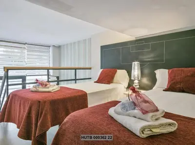 a hotel room with two beds and two tables at Alcam Futbol Pequeño in Barcelona
