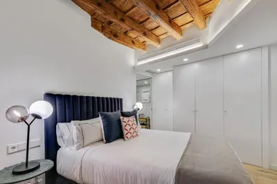 a bedroom with a large bed with a blue headboard at CATERINA Correos in Barcelona