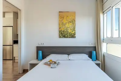 a bedroom with a white bed and a painting on the wall at 2514 - AB Comte dUrgell V-II in Barcelona