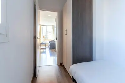 a bedroom with a white bed and a hallway at 2514 - AB Comte dUrgell V-II in Barcelona