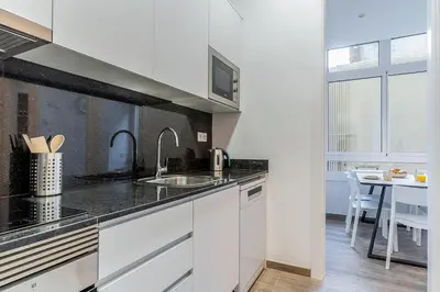 a white kitchen with a sink and a table at 4190 - AB Comte dUrgell P-I in Barcelona