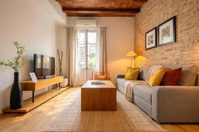 a living room with a couch and a brick wall at Boutique Pare Lainez in Barcelona