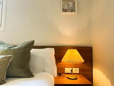 a lamp on a table next to a bed at Boutique Pare Lainez in Barcelona