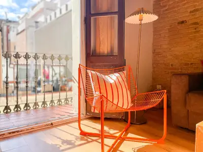 an orange chair on a balcony with a lamp at Boutique Pare Lainez in Barcelona
