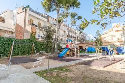 a playground in a park in front of a building at Horizonte Azul Sitges in Sitges