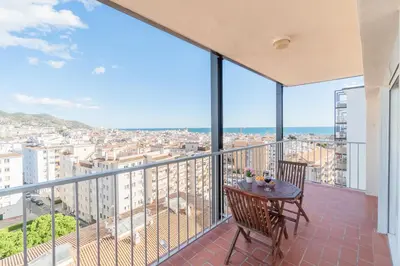 a balcony with a table and a view of a city at Horizonte Azul Sitges in Sitges