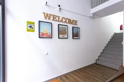 a staircase with three pictures on the wall and a welcome sign at StayCampNou Studio with Balcony in Hospitalet de Llobregat
