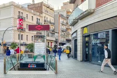 a man walking down a street next to a store at StayCampNou Studio with Balcony in Hospitalet de Llobregat