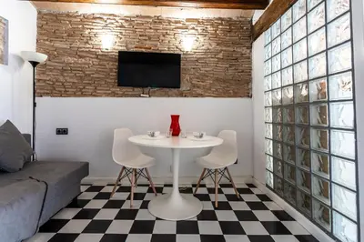 a living room with a table and chairs and a tv at Apartamento La Boqueria 3 in Barcelona