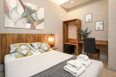 a bedroom with a bed with towels on it at Jardinets Guest House in Barcelona