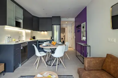 a kitchen and living room with a table and chairs at Habitat Apartments Free Jazz in Barcelona