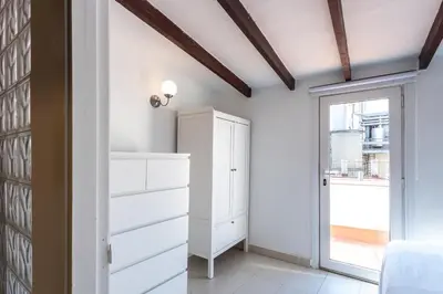 a dressing room with white dressers and a window at Apartamento La boqueria Atic in Barcelona