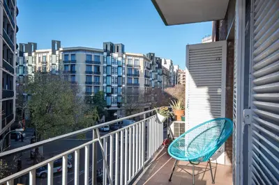 a balcony with a blue chair and a view of a city at Warmth and comfort in the sought-after Eixample in Barcelona
