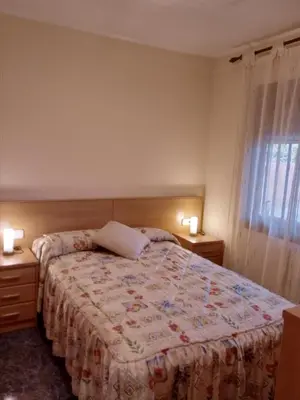 a bedroom with a bed with two night stands and two lamps at Casa en Barcelona in Papiol