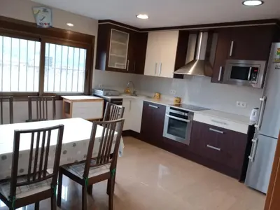 a kitchen with a table and chairs and a refrigerator at Casa en Barcelona in Papiol