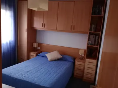 a bedroom with a blue bed and wooden cabinets at Casa en Barcelona in Papiol