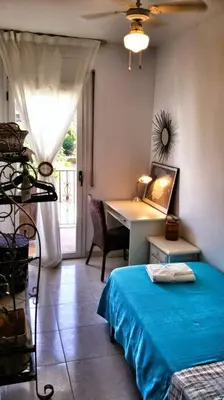 a bedroom with a bed and a desk and a table at Preciosa casa en el centro con terraza y patio in Sitges