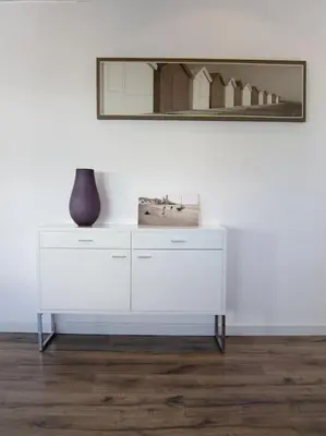 a white dresser with a vase and a mirror at Preciosa casa en el centro con terraza y patio in Sitges