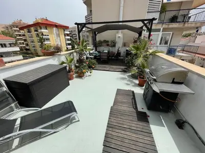 a balcony with a table and a boat on a building at Preciosa casa en el centro con terraza y patio in Sitges