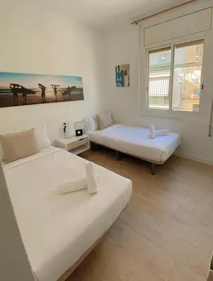 a room with two beds and a window at Sitges Best Holidays Apartment in Sitges