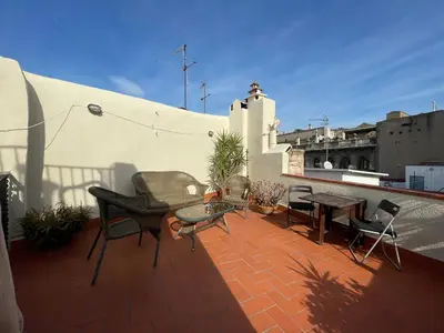 a patio with chairs and tables on a roof at Original duplex in the center of Barcelona in Barcelona
