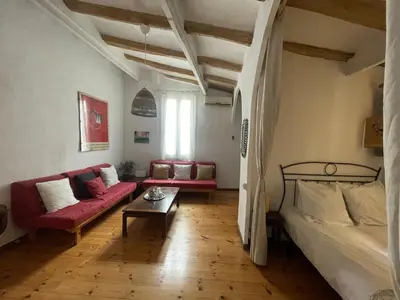 a living room with a couch and a bed and a table at Original duplex in the center of Barcelona in Barcelona