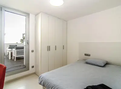 a bedroom with a bed and a window with a table at Duplex vistas mar con piscina in Sant Pere de Ribes