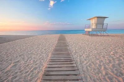 a wooden path leading to a lifeguard station on the beach at Holiday home in Calella de la Costa 3641 in Calella