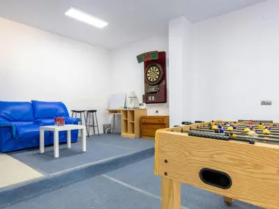 a room with a couch and a table and a clock at Holiday Home Villa Rosales by Interhome in Gornal
