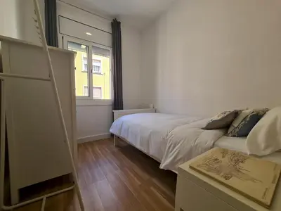 a small bedroom with a bed and a window at WALK to CAMP NOU - Wi-Fi AC 3 Bed by MyRentalHost in Hospitalet de Llobregat