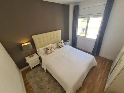 a bedroom with a white bed and a window at WALK to CAMP NOU - Wi-Fi AC 3 Bed by MyRentalHost in Hospitalet de Llobregat