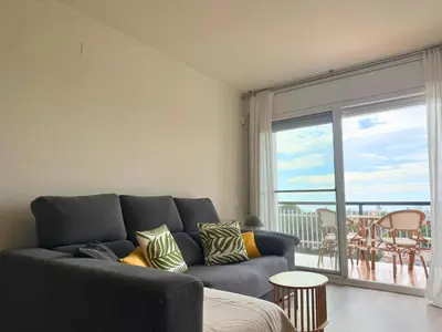 a living room with a couch and a large window at Atico Isabel in Castelldefels