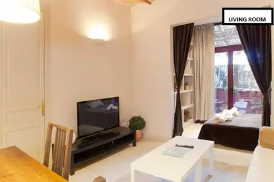 a living room with a couch and a tv and a table at Family apartment Plaza España in Barcelona