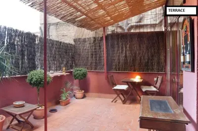 a patio with a table and chairs and plants at Family apartment Plaza España in Barcelona