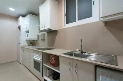 a kitchen with white cabinets and a sink at Family apartment Plaza España 2 in Barcelona