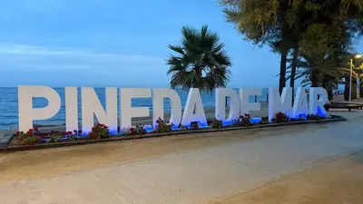 a large sign that reads pismo beach with flowers at The White Lilies in Pineda de Mar