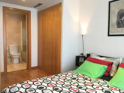 a bedroom with a bed with green and red pillows at Apartment familiar in Barcelona