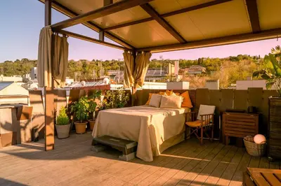 a bed on a patio with a roof at Apartment with Terrace Views of BCN in Barcelona
