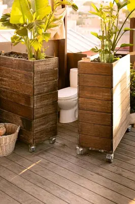 a bathroom with a toilet and two potted plants at Apartment with Terrace Views of BCN in Barcelona