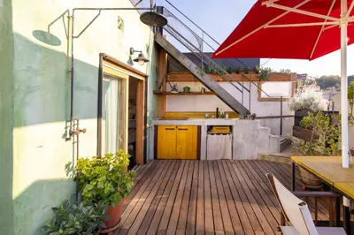 a wooden deck with a table and an umbrella at Apartment with Terrace Views of BCN in Barcelona