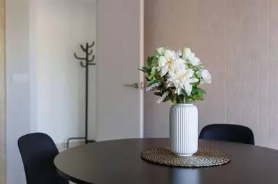a vase of white flowers sitting on a table at Housalia Casa del Mar en Vila Olímpica in Barcelona