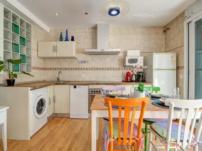 a kitchen with a table and chairs and a sink at Carmen Apartment by Hello Homes Sitges in Sitges