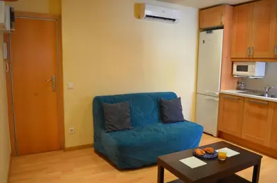 a living room with a blue couch and a table at Apartment Bed&BCN Sant Andreu II in Barcelona
