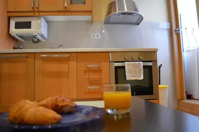 a plate of bread on a table with a glass of orange juice at Apartment Bed&BCN Sant Andreu II in Barcelona