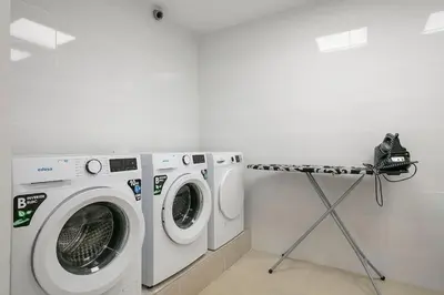 a laundry room with two washing machines and a camera at YOUR HOME- Apartment Camp Nou 2a in Hospitalet de Llobregat