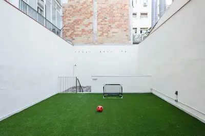 a soccer ball on a green field in an empty building at YOUR HOME- Apartment Camp Nou 2a in Hospitalet de Llobregat