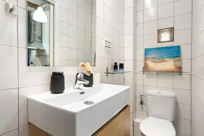 a white bathroom with a sink and a toilet at Lodging Apartments Almirall Beach 22 in Barcelona