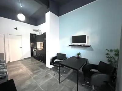 a living room with a table and chairs and a tv at Studio Sagrada Familia in Barcelona